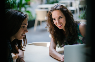 Two Women Looking At Laptop Screen