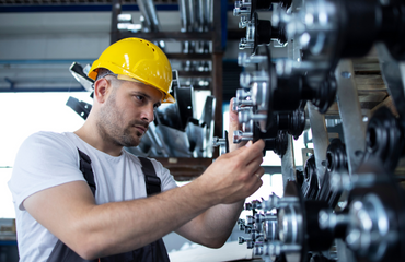 Engineer Working On Equipment with Yellow Hardhat