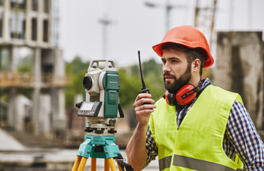 Male Surveyor with equipment and high vis 