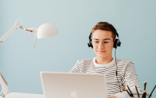 Young Adult With Laptop And Headphones On