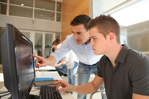 Two men in library looking at computer