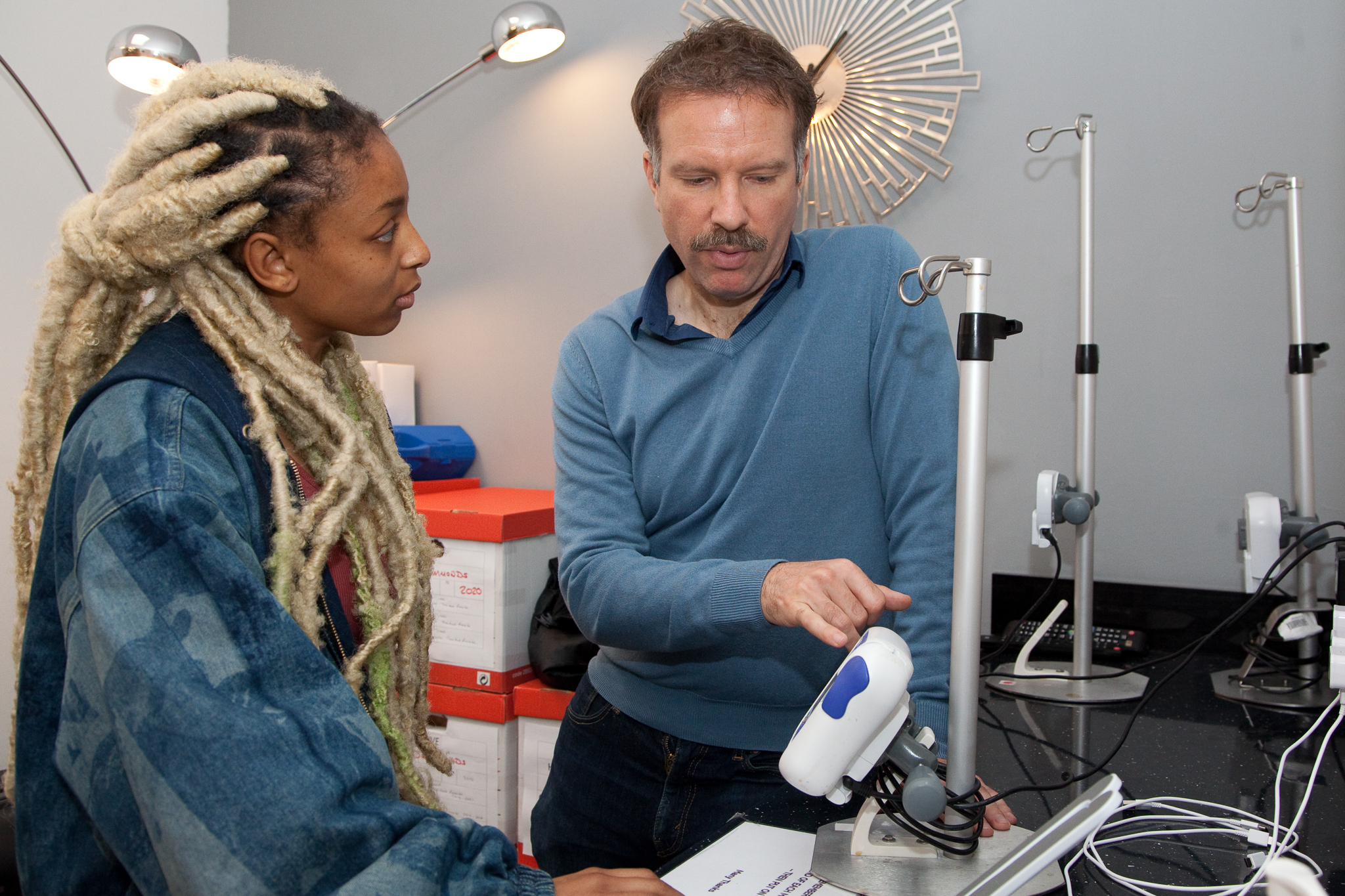 Care Worker and patient talking and looking At Equipment