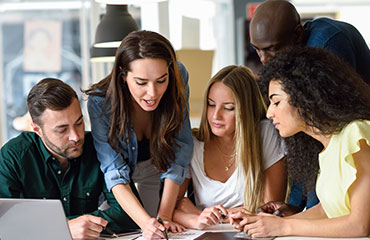 Group Of Students Looking At Peice Of Work