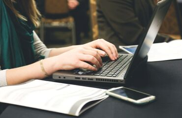 Laptop User with phone on table 